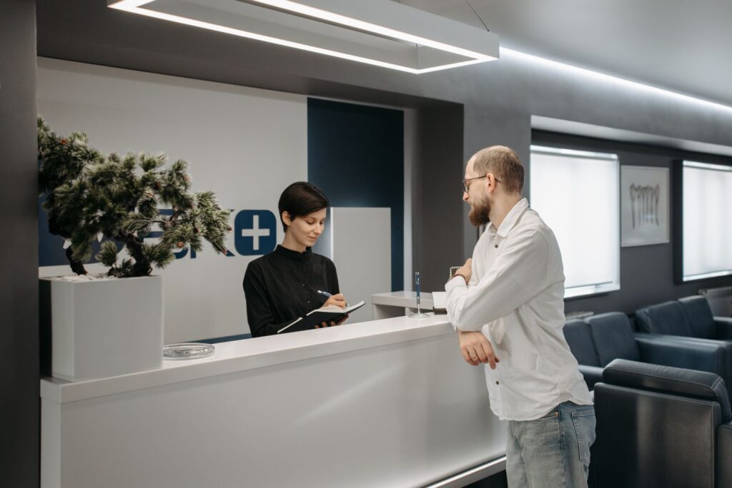 Patient checking in at a clinic reception desk