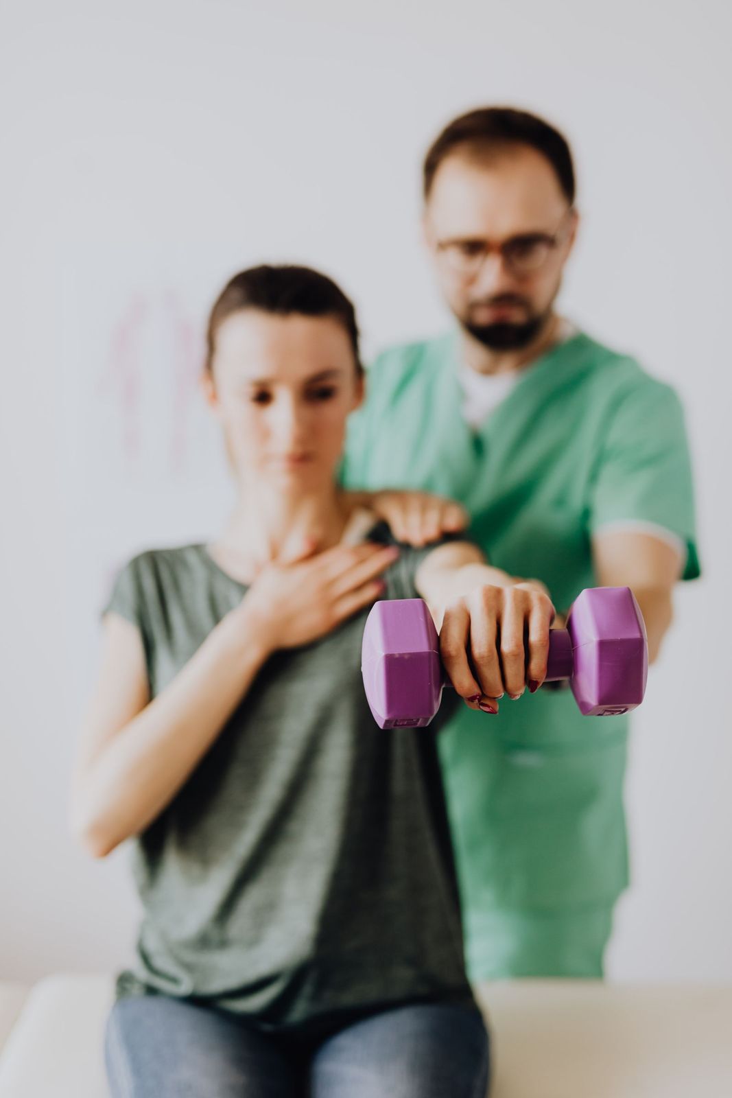 Physical therapist helping a patient with shoulder exercises